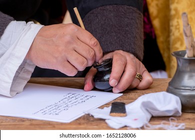 Close-up Of A Medieval Scribe, With A Pen, Paper And An Inkwell