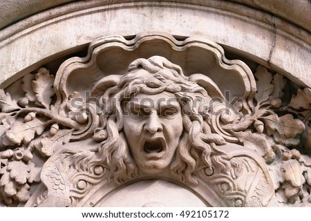 Closeup of Medusa's head carved on the stone facade
