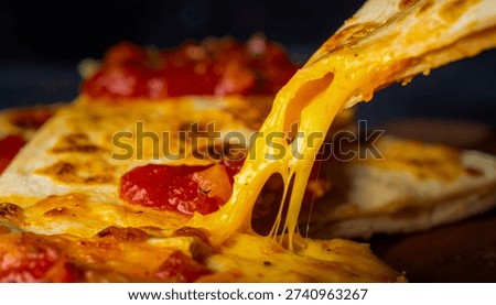 Close-up of melted cheese being pulled from a pizza slice with tomato sauce and melted mozzarella