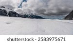 Close-up of a melting Alaskan glacier with vibrant blue meltwater pools, surrounded by snow and ice. A stunning glimpse into the Arctic wilderness and climate change.