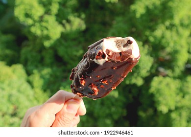 Closeup A Melting Chocolate Dipped Ice Cream Bar In Hand On A Sunny Day