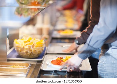 Close-up Of Men In Line With Food Trays In Work Cafeteria