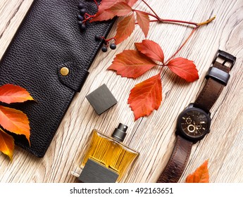 Closeup of men's accessories and essential items on wooden background. Decorated with autumn red leaves. Flat lay, top view, view from above - Powered by Shutterstock