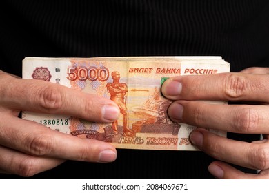 Close-up men's hands hold a wad of Russian money five thousand bills.