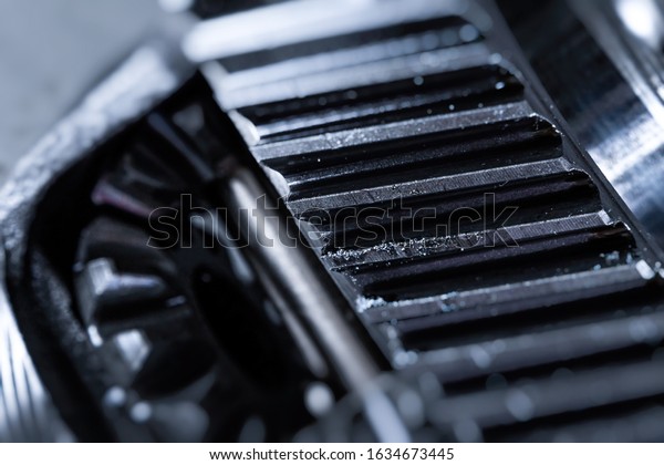 Close-up of a metal automobile spare part from\
a supported car on a metal table in a car service center.  Metal \
autotechnology\
background