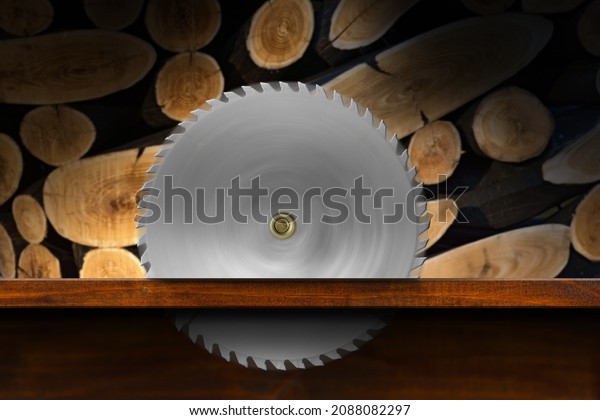 Close-up of a metal circular saw blade
in motion in a wooden workbench with a group of sawn logs in the
background. Carpentry and Lumber industry
concept.