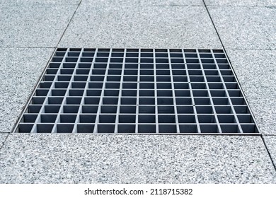 Close-up, metal cover of street water drain. Against the background of paving slabs of gray granite - Powered by Shutterstock