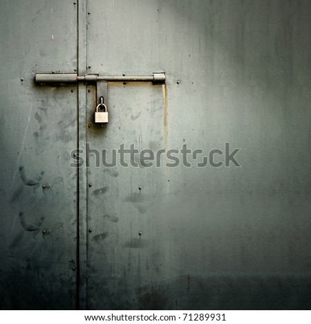 Closeup metal door with lock in grungy style and good texture.