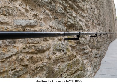 Close-up Of A Metal Handrail On An Old Stonewall