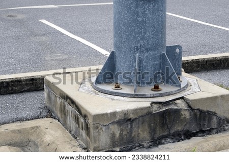 Close-up of a metal stand on a cement of the bright lamp post in the carpark.