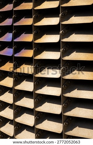 Closeup of metal ventilation structure creating repetitive geometric pattern