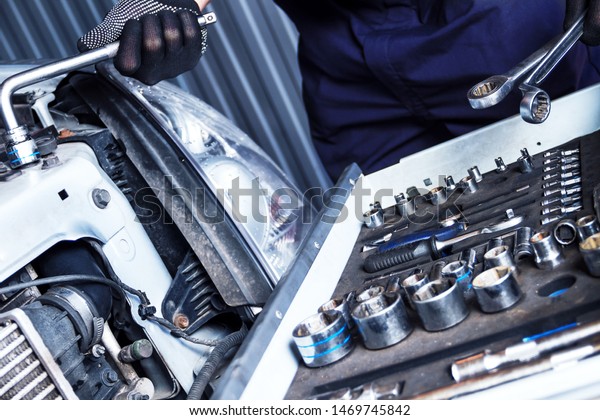 Closeup metal work tool of car mechanic at workshop auto\
repair shop. Repairman is choosing wrench for fixing vehicle.\
Repairer is repairing automobile at modern service station garage. \
