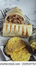 A Closeup Of Mexican Burritos Wrapped With Pork And Vegetables