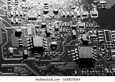 A close-up microchip with many electrical components placed on the Board. The background is blurred.