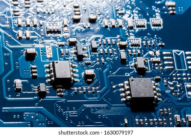 A close-up microchip with many electrical components placed on the Board. The background is blurred.