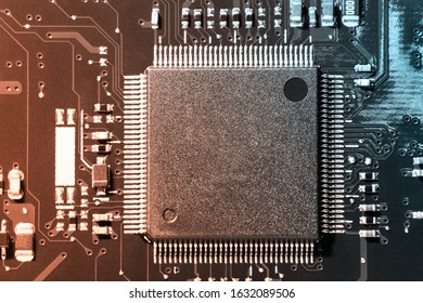 A close-up microchip with many electrical components placed on the Board. The background is blurred.