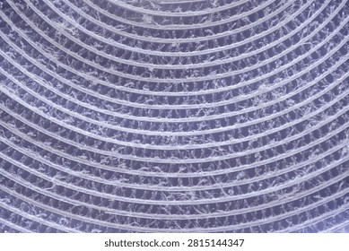 Closeup micrograph showing hook loop fibers in concentric rows, fine spiral pattern, high magnification with cool blue tint, industrial textile analysis, laboratory imaging