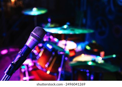 Close-up of a microphone illuminated by purple neon light. Preparation for the concert. Drummer's place close-up. Rock concert in the bar.  - Powered by Shutterstock