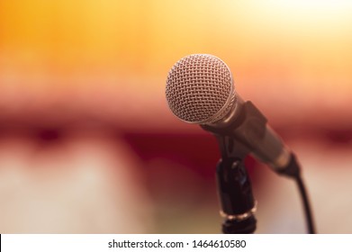 Closeup Of Microphone On Abstract Blurred Background Speech In Seminar Convention Hall Room And Light As Guest And Conference Speaker On Podium. Workshop Event And Entertainment Broadcast Concept.