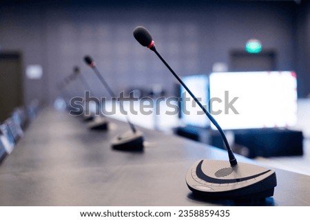 Close-up of microphones in an empty meeting room at a press conference.