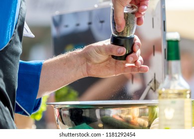 Closeup mid section of a chef putting salt and Pepper in the kitchen - Powered by Shutterstock