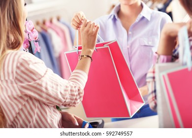 Closeup mid section of female customer receiving shopping bags in boutique