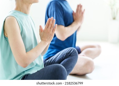 closeup of middle aged couple doing yoga meditation - Shutterstock ID 2182536799