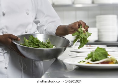 Closeup midsection of a chef preparing salad in the kitchen - Powered by Shutterstock