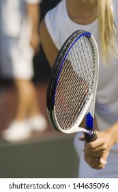 Closeup Midsection Of A Tennis Player With Racket Waiting For Doubles Partner To Serve