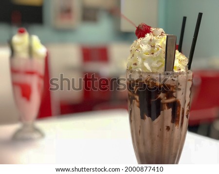 Close-up of milkshake, in a diner setting. 
