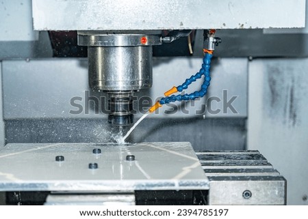 Close-up of a milling cnc machine using cutting fluid to cut a mould