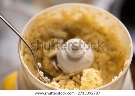 Close-up of Minced Garlic or Ginger Paste in a Food Processor Bowl with a Spoon