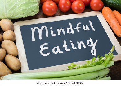 Close-up Of Mindful Eating Text On Slate Surrounded With Organic Vegetables - Shutterstock ID 1282478068