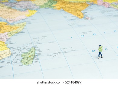 Closeup Of Miniature Figurine Of Young Traveler Standing On Big Map Next To The Indian Ocean Region