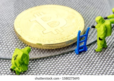 closeup of miniature figurines dressed like members of firemen special team interfering during gas and other chemical accidents with the action protecting/saving bitcoin, crypto world with a shield