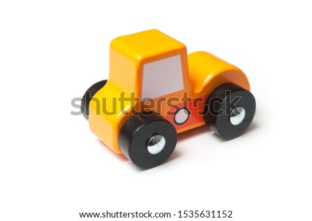 Closeup of miniature toy, wooden orange color car on white background