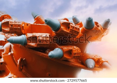 Close-up of mining drill bit equipment in industrial setting.