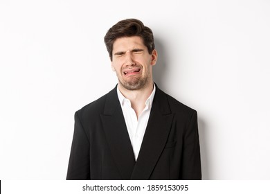 Close-up Of Miserable Man In Suit, Crying And Sobbing, Feeling Sad, Standing Against White Background