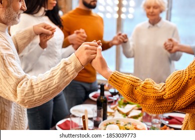 Close-up Of Mixed Race Family Hands Crossed Other During Prayer Before Holiday Dinner At Home. Christmas, New Year, Thanksgiving, Anniversary, Hanukkah, Easter, Mothers Day Celebration Concept