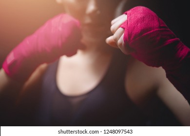 Close-up Of MMA Girl Holding Fists Pink Boxing Bandages To Protect Her Fingers In Fight. Concept Women Self-defence