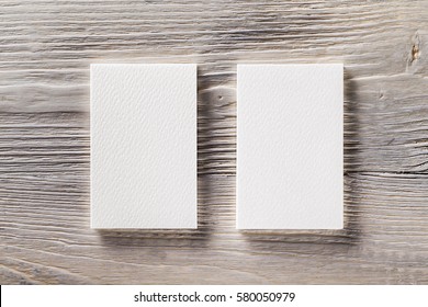 Closeup Mockup Of Two Blank Vertical Business Cards At Light Natural Wooden Background.