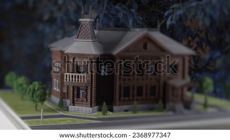 Close-up model of old house. Stock footage. Mock-up of old wooden manor house with garden. Light effect of changing days on small layout with house