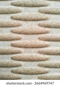 Close-up of a modern abstract surface pattern with a raised texture. The horizontal ellipses, neatly arranged in a staggered format, create a 3D illusion