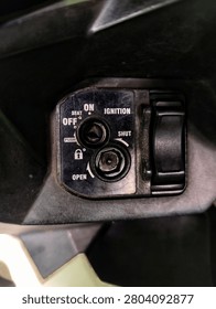 Close-up of a modern automatic motorcycle ignition key switch shutter panel with seat release button