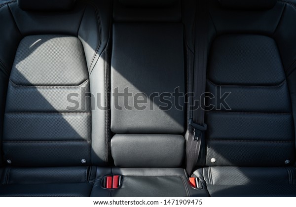 Closeup of a modern car interior with the black\
leather rear seats