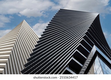 Close-up of a modern glass office building. Reflection of the sky with clouds in the glass of the building. Building exterior, business, construction industry. - Powered by Shutterstock