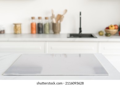 Closeup of modern induction cooker in Nordic kitchen. Kitchenware and decor on background. House after renovation. Modern appliances and household equipment, selective focus