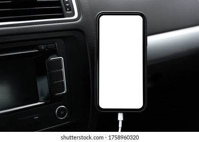 Close-up Of Modern Smartphone With Empty White Mockup On Screen, Standing On Holder Of Car Dashboard.