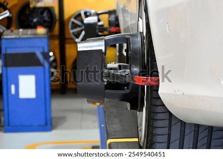 A close-up of a modern tire alignment machine in an automotive workshop.
