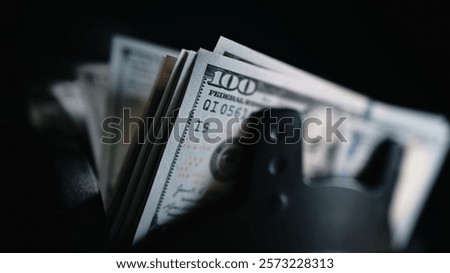 Close-up of a money counting machine sorting hundred dollar bills for currency exchange or cash deposit. Automatic banknote counter in action. Concept of finance, banking and investment. 